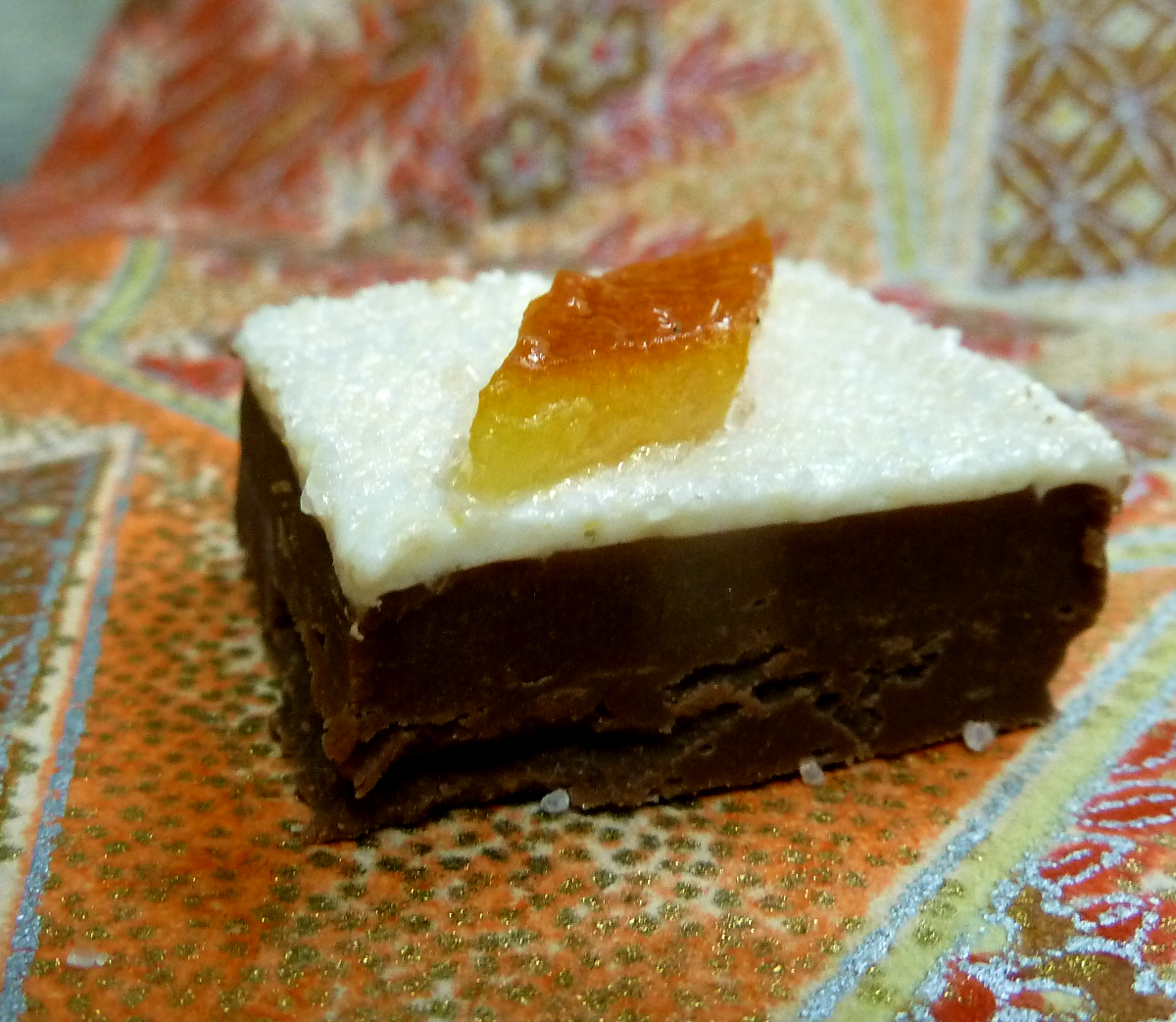 A sliver of candied Minneola tangelo atop Minneola marshmallow on a bed of Tikal Guatemalan 43% milk chocolate butter ganache.