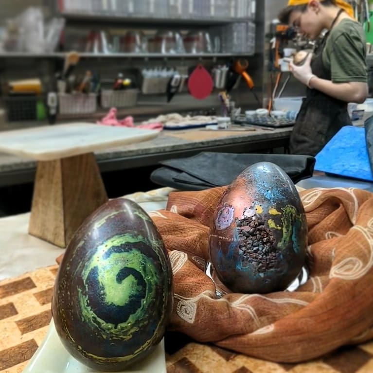 JAPANESE ART EGGS - India dark chocolate shell filled with layers of black sesame brown sugar caramel and blood orange marshmallow, with a peach saffron paté de fruit "yolk." The final photo shows the back of each egg. Yeah, I was in the mood to paint. #chocolatier #chocolateasart #japanesepainting #chocolateegg That's Rachel in the background working on one of our crazy special projects. Not saying any more about that at the moment.